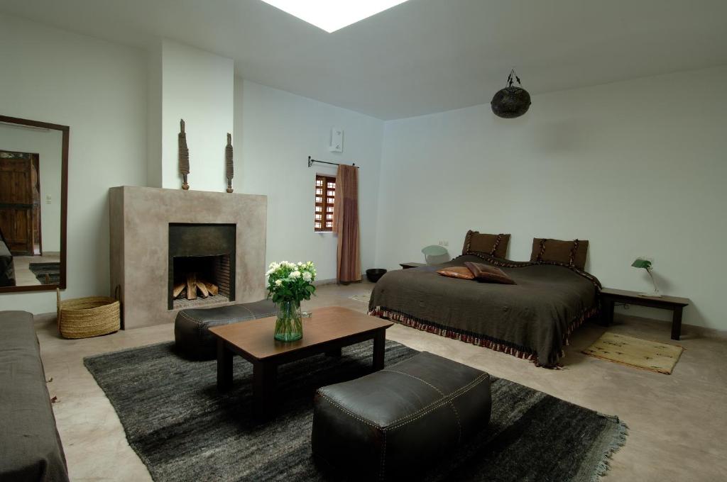 - un salon avec un lit et une cheminée dans l'établissement Riad UP, à Marrakech