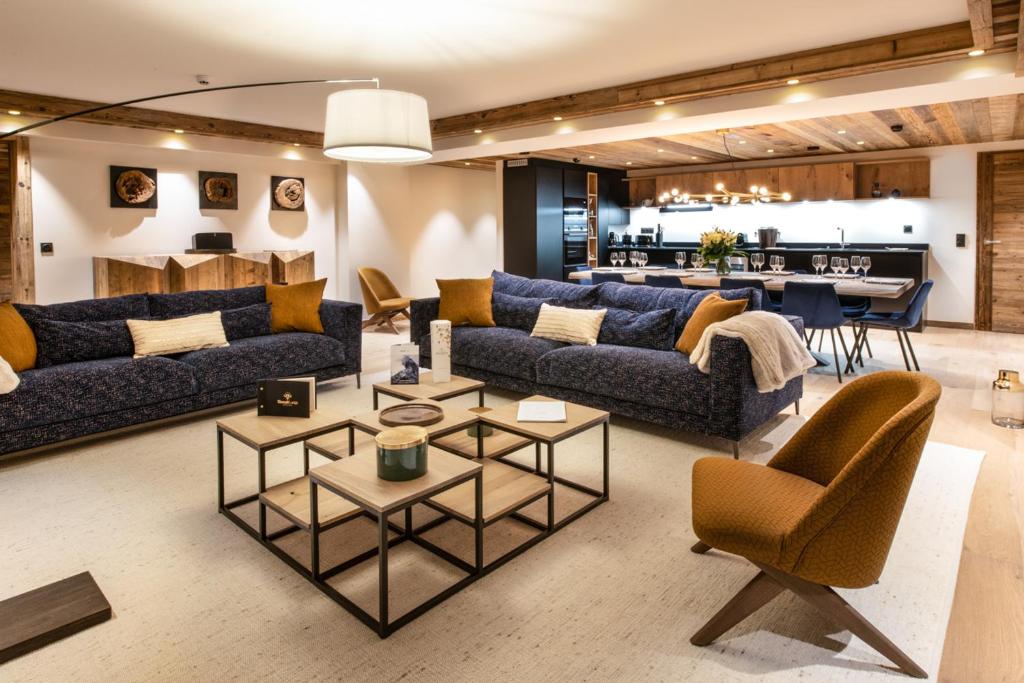 - un salon avec des canapés et une salle à manger dans l'établissement Manali Lodge by Alpine Resorts, à Courchevel