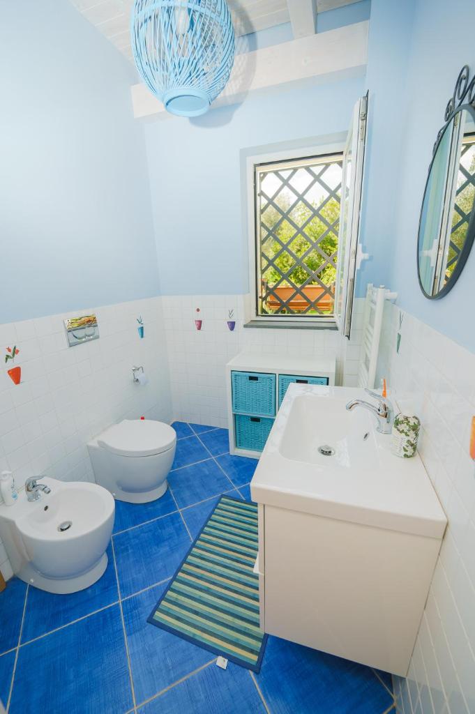 une salle de bain bleue et blanche avec des toilettes et un lavabo dans l'établissement villa dei limoni Etna-mare, à Acireale
