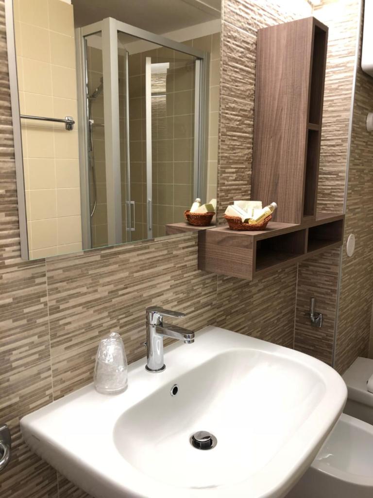 une salle de bain avec un lavabo et un miroir et des toilettes dans l'établissement Hotel Le Tre Isole, à Magione