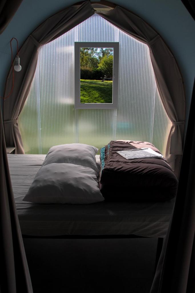 - un lit dans une tente avec fenêtre dans l'établissement Camping Au Coeur de Vendome, à Vendôme