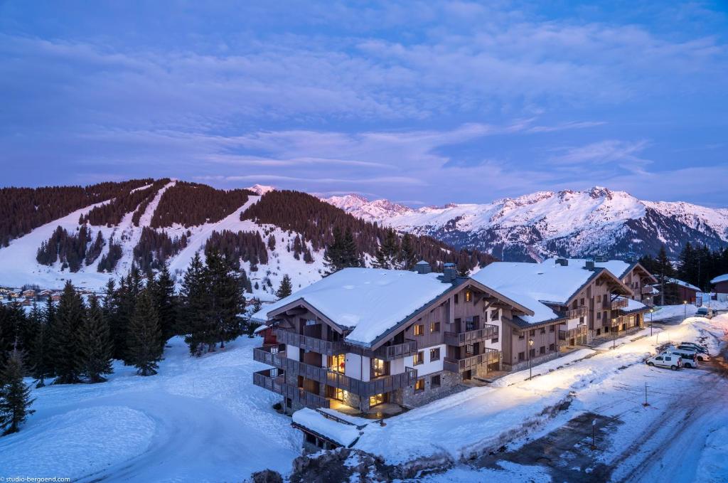 un lodge dans la neige avec des montagnes enneigées dans l'établissement MGM Hôtels & Résidences - Résidence Amaya, à Villard-sur-Doron