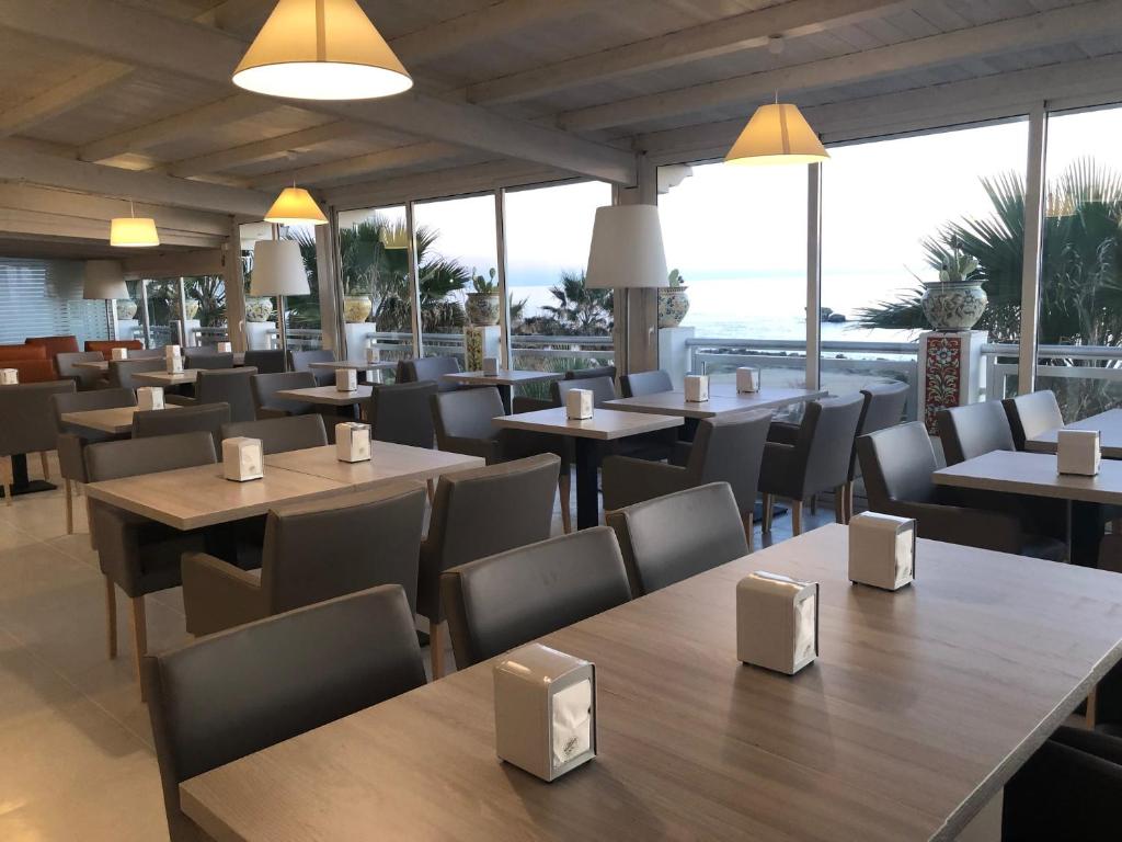un restaurant avec des tables, des chaises et des fenêtres dans l'établissement Hotel Sul Mare Al Gabbiano, à Scoglitti 57 autres photos