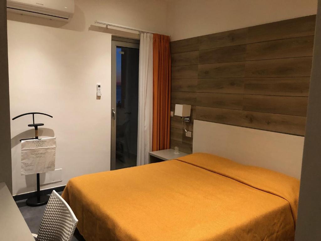 une chambre avec un lit et un mur en bois dans l'établissement Hotel Sul Mare Al Gabbiano, à Scoglitti