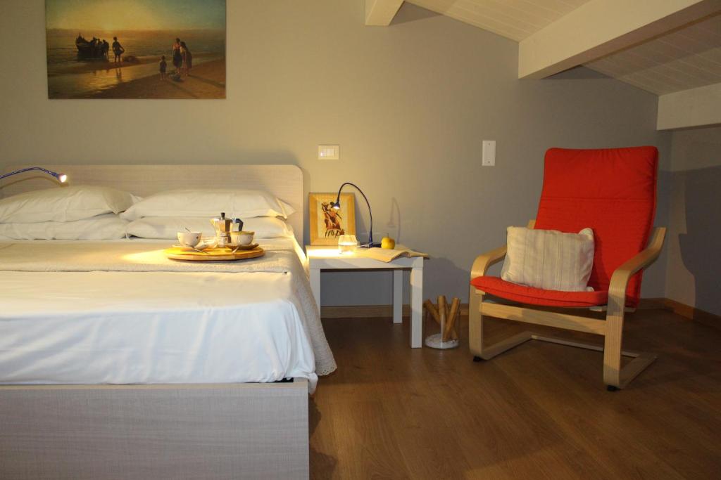 une chambre avec un lit, une chaise et une table dans l'établissement Otium casa vacanze-servizio spiaggia incluso a 250 mt-struttura pet friendly, à Giulianova