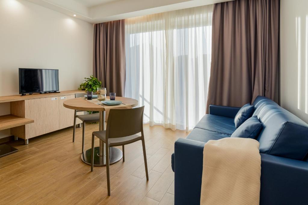 un salon avec un canapé bleu et une table dans l'établissement Hotel Serenella, à Agropoli