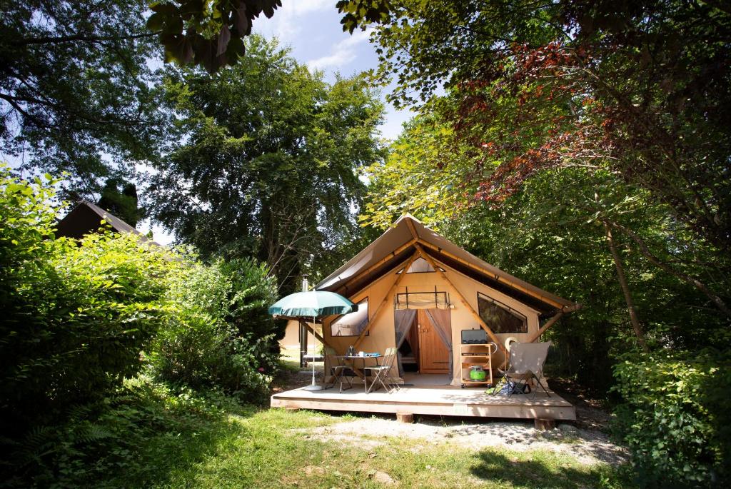 une petite tente au milieu d'une forêt dans l'établissement Huttopia Lac d'Aiguebelette, à Saint-Alban-de-Montbel