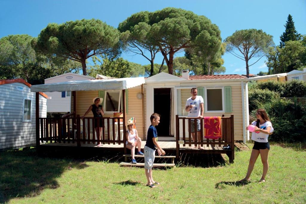 Une famille jouant au frisbee devant une petite maison dans l'établissement Camping Montana Parc - Gassin Golfe de St Tropez - Maeva, à Gassin