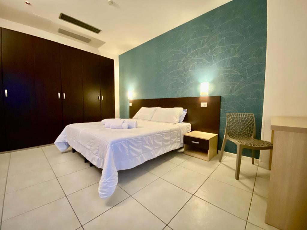 une chambre avec un lit blanc et une chaise dans l'établissement Residence Acqua Suite Marina, à Rimini 54 autres photos