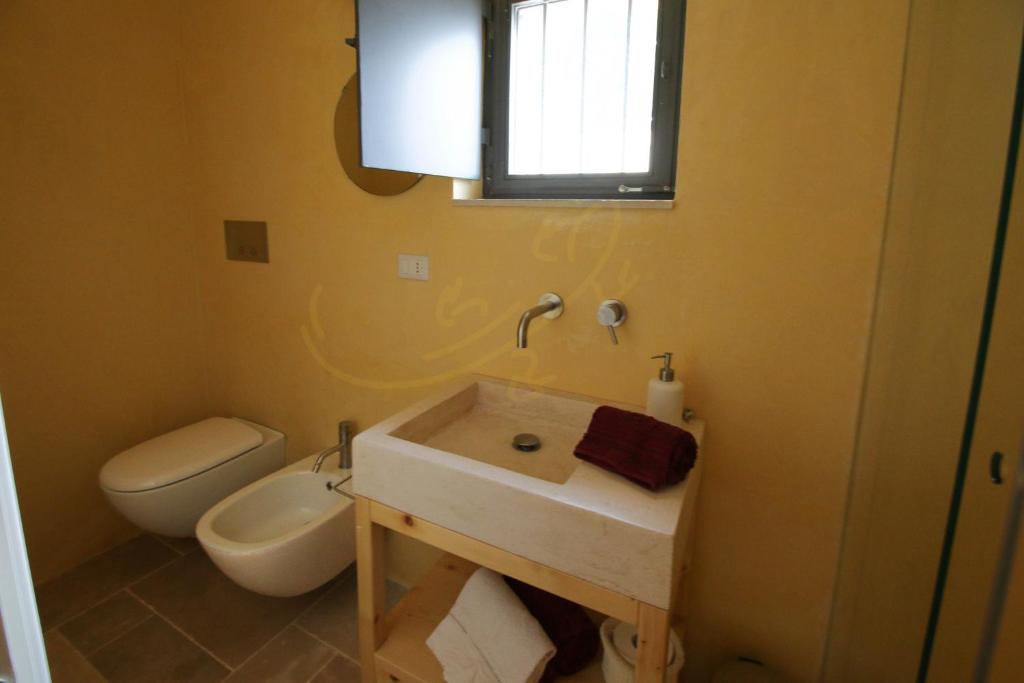 une salle de bain avec un lavabo et des toilettes dans l'établissement TD Casale Terranova Stone Farmhouse with Pool, à Monopoli 9 autres photos