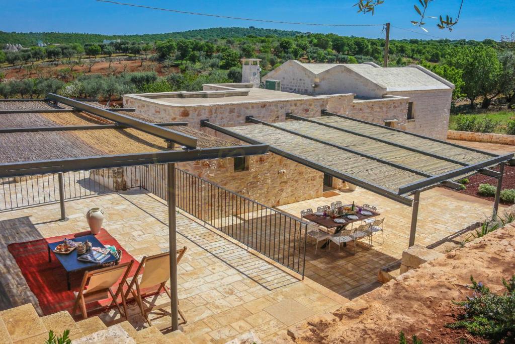 Elle offre une vue sur la terrasse dotée d'une table et d'une table. dans l'établissement TD Casale Terranova Stone Farmhouse with Pool, à Monopoli