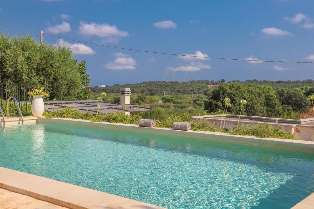 une piscine avec de l'eau bleue dans une cour dans l'établissement TD Casale Terranova Stone Farmhouse with Pool, à Monopoli