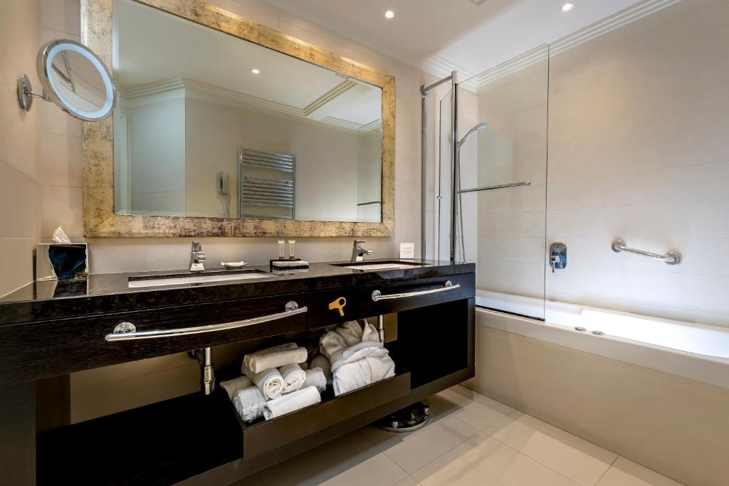 une salle de bain avec un lavabo et un miroir dans l'établissement Hotel Ambasciatori, à Rimini