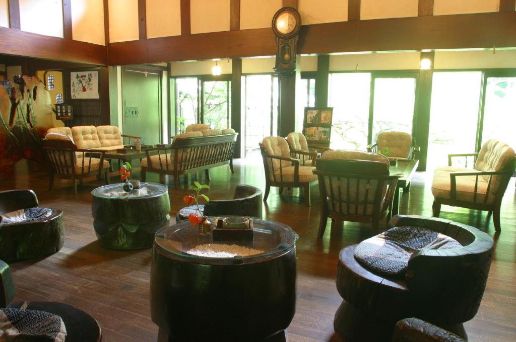 un hall d'entrée avec des chaises, des tables et une horloge dans l'établissement Yumoto Choza, à Takayama