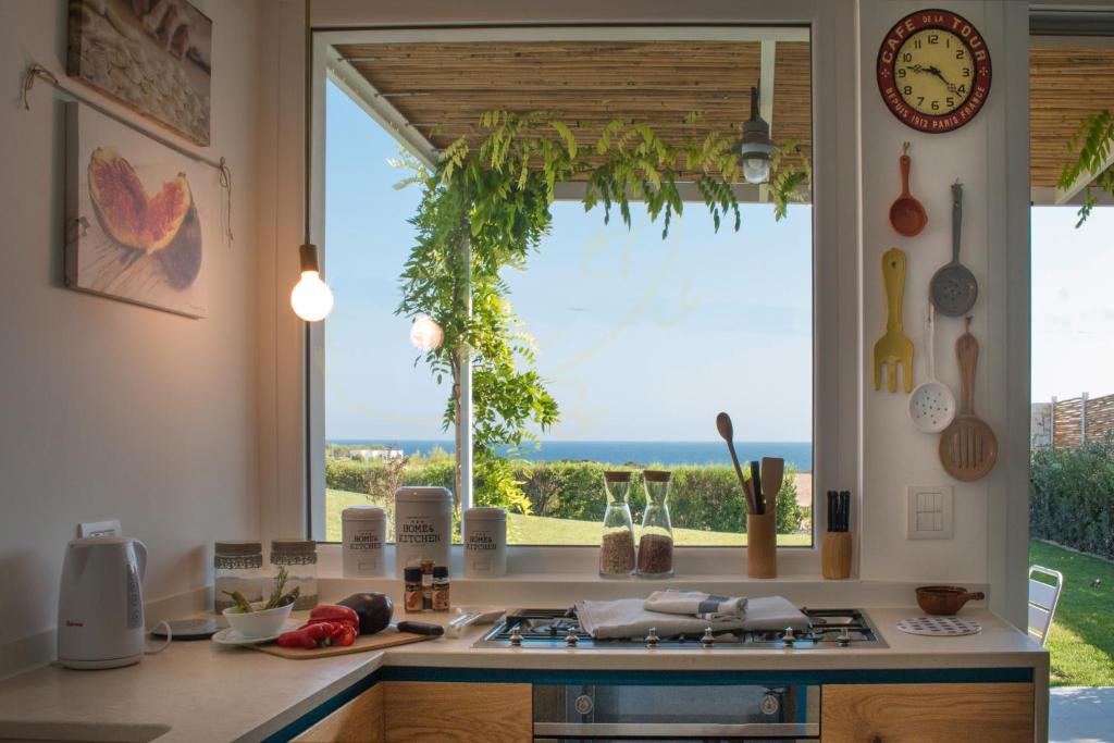- une cuisine avec une fenêtre offrant une vue sur l'océan dans l'établissement TD Villa Ponente Luxury Villa with Sea View Pool, à Monopoli