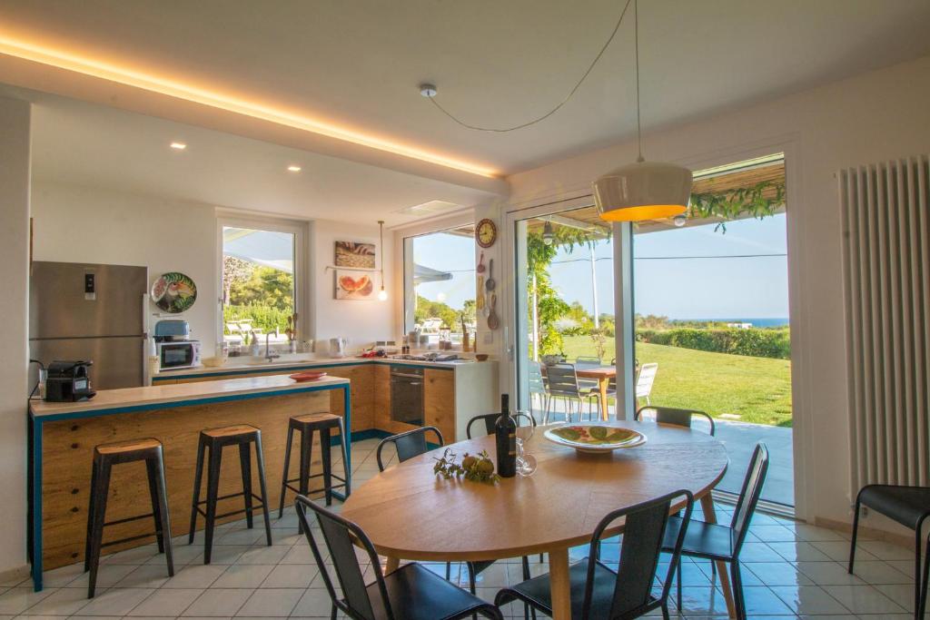 une cuisine et une salle à manger avec une table et des chaises dans l'établissement TD Villa Ponente Luxury Villa with Sea View Pool, à Monopoli