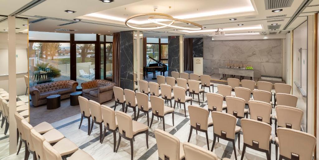 une salle avec des rangées de chaises dans une salle de conférence dans l'établissement Hotel Sporting, à Rimini 94 autres photos