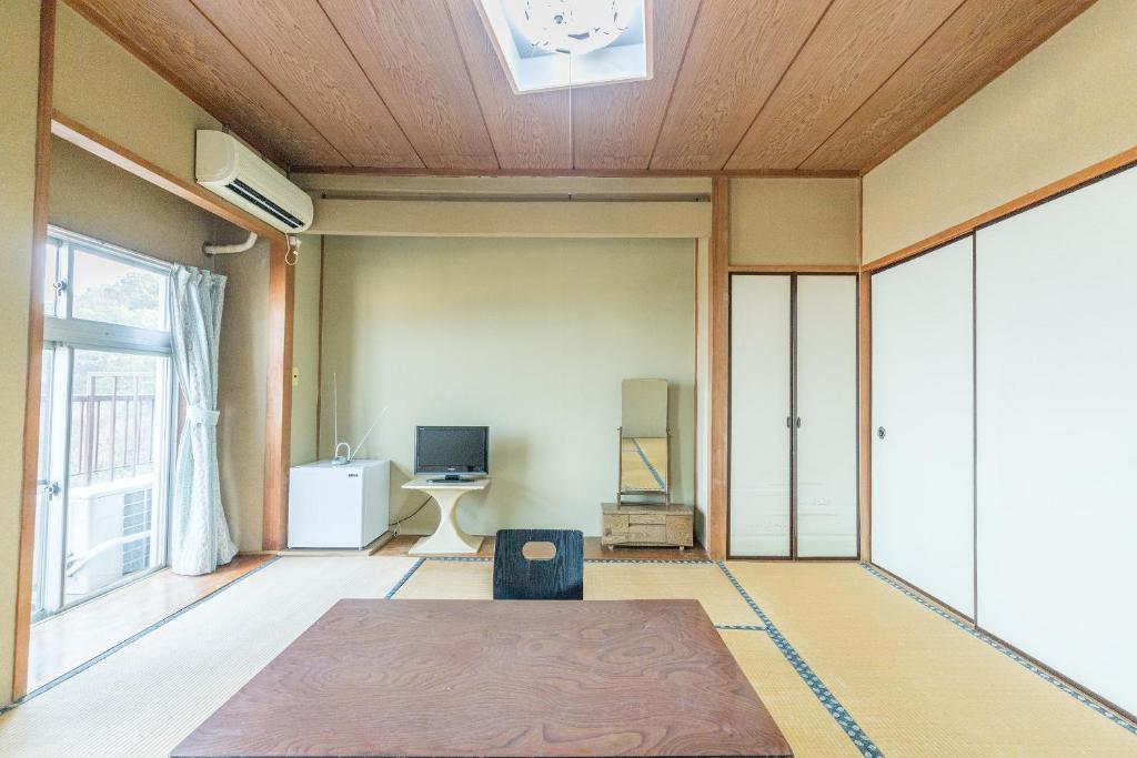une chambre avec une table et une horloge au plafond dans l'établissement Tabist Miyoshi Ryokan Odawara Manazuru, à Odawara