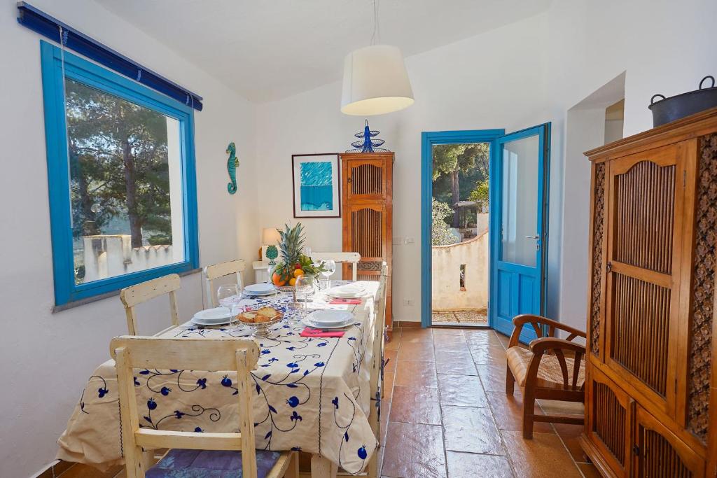 une salle à manger avec une table et une porte bleue dans l'établissement Casa di Cri, à San Vito Lo Capo