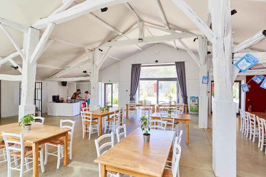 une grande pièce avec tables et chaises et une cuisine dans l'établissement Domaine de l'Oiselière, à Chauché