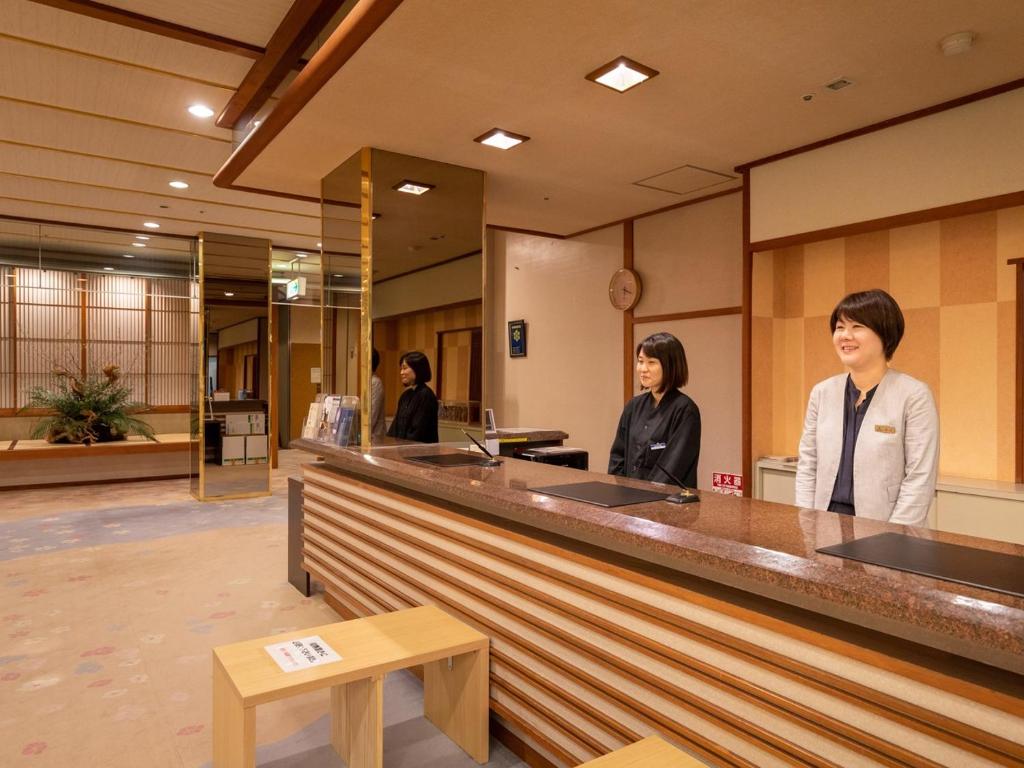Deux femmes se tenant au comptoir dans un hall dans l'établissement Tamai Bekkan, à Matsue