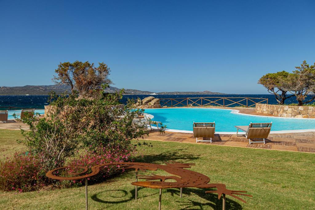 une vue sur une piscine avec une table et des chaises dans l'établissement Hotel Sporting, à Porto Rotondo