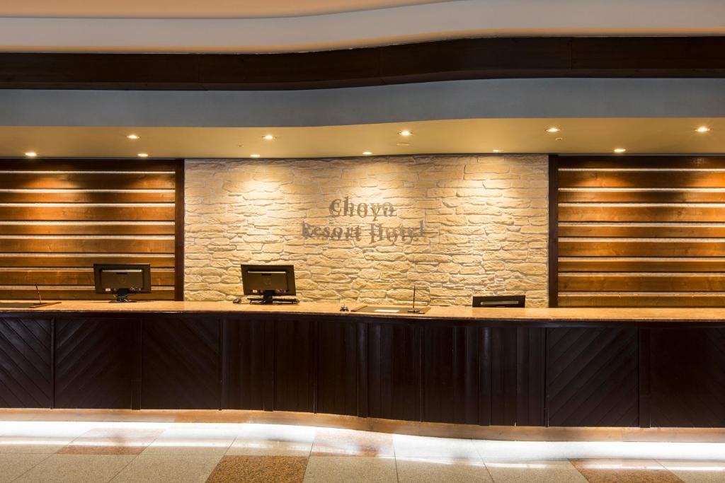 dans le hall de l'hôtel, vous trouverez un comptoir de réception avec un mur en pierre. dans l'établissement Choyo Resort Hotel, à Kamikawa 37 autres photos
