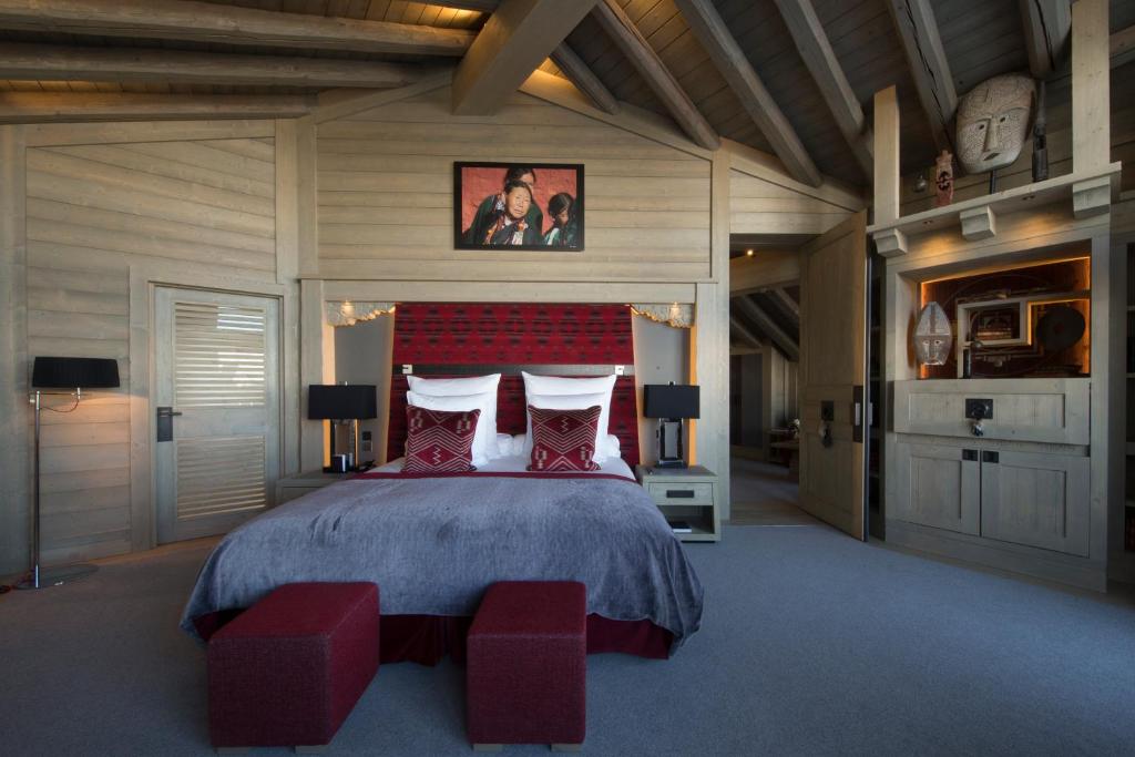 une chambre avec un grand lit avec des oreillers rouges dans l'établissement Hotel Le K2 Altitude, à Courchevel