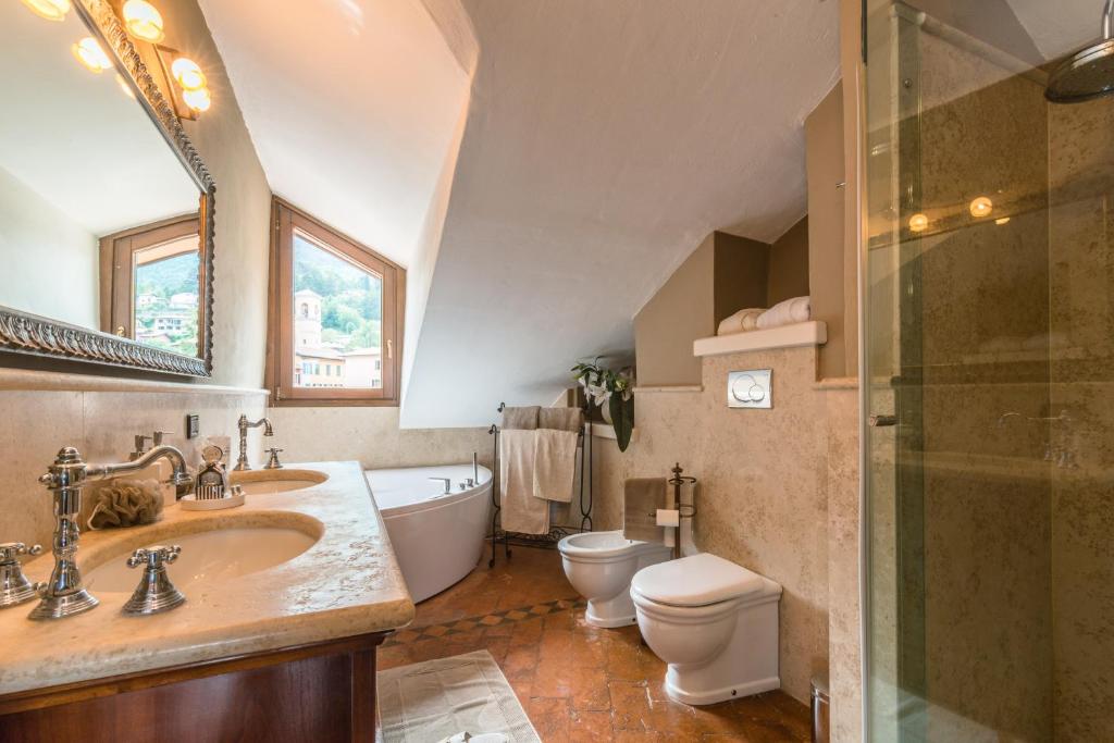 une salle de bain avec un lavabo, une baignoire et des toilettes dans l'établissement The Lake Como Villa, à Menaggio
