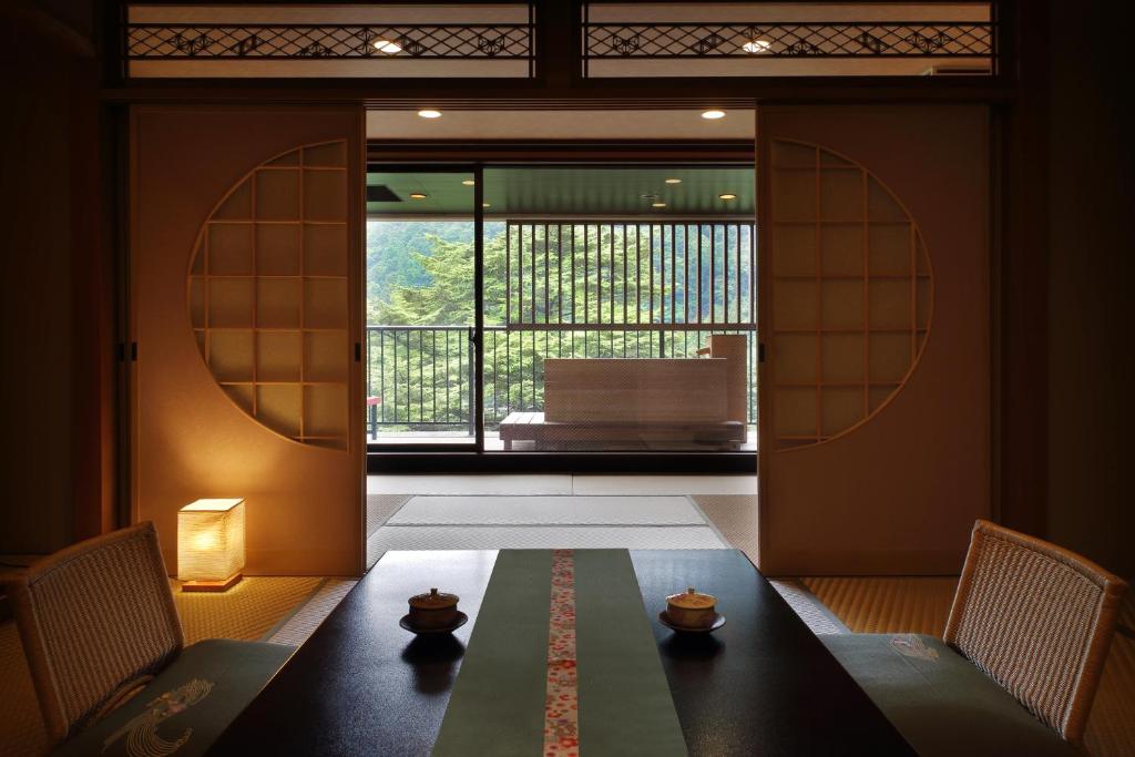 une pièce avec une table, des chaises et une fenêtre dans l'établissement Tsuganoki, à Nikkō