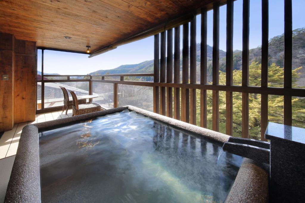 - une piscine dans un bâtiment avec vue sur la montagne dans l'établissement Tsuganoki, à Nikkō