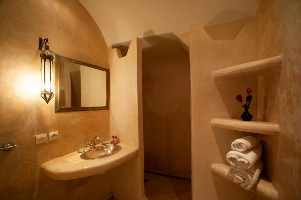une salle de bain avec un lavabo et un miroir dans l'établissement Riad des trois palais, à Marrakech