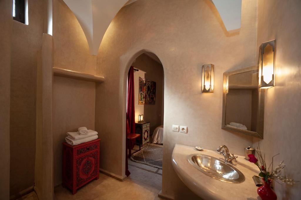 une salle de bain avec un lavabo et un miroir dans l'établissement Riad des trois palais, à Marrakech
