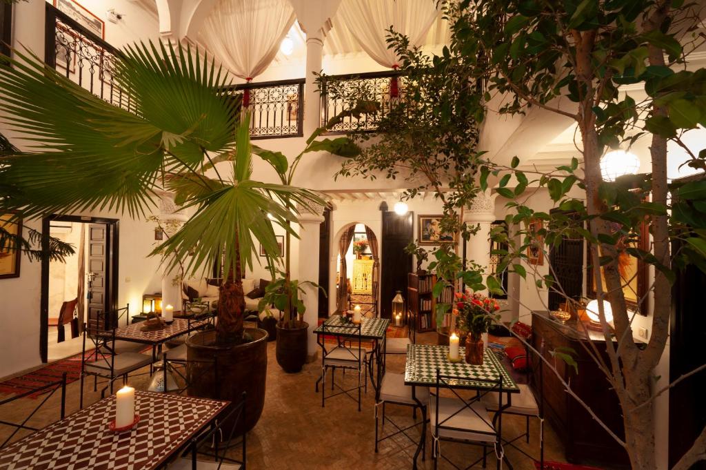 Cette chambre comprend des tables, des plantes et des bougies. dans l'établissement Riad des trois palais, à Marrakech