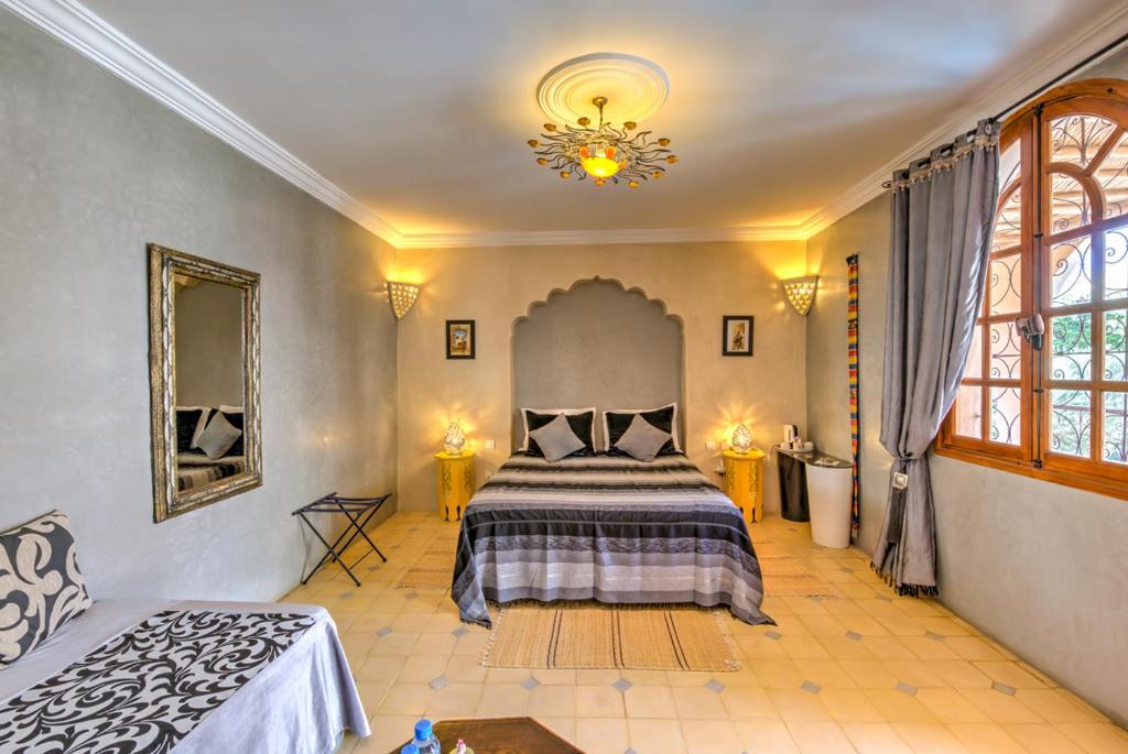 une chambre avec un lit et un lustre dans l'établissement Riad Janoub, à Tiznit