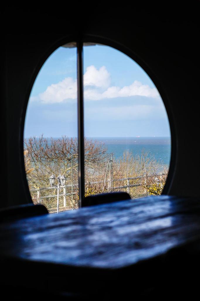 une vue sur l'océan depuis une fenêtre dans l'établissement Cottages Domaine du Grand Bec, à Villerville