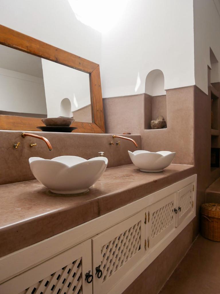 2 bols blancs sur un comptoir avec miroir dans l'établissement Riad Dar Aman, à Marrakech