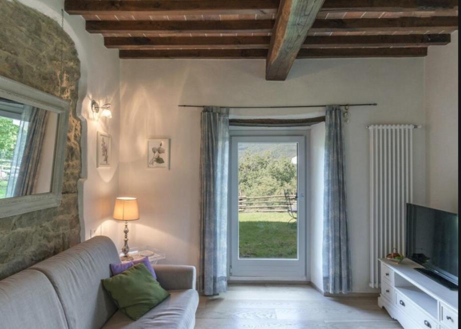 un salon avec un canapé et une porte coulissante en verre dans l'établissement Villa Galearpe with private pool in Tuscany, à Salutio
