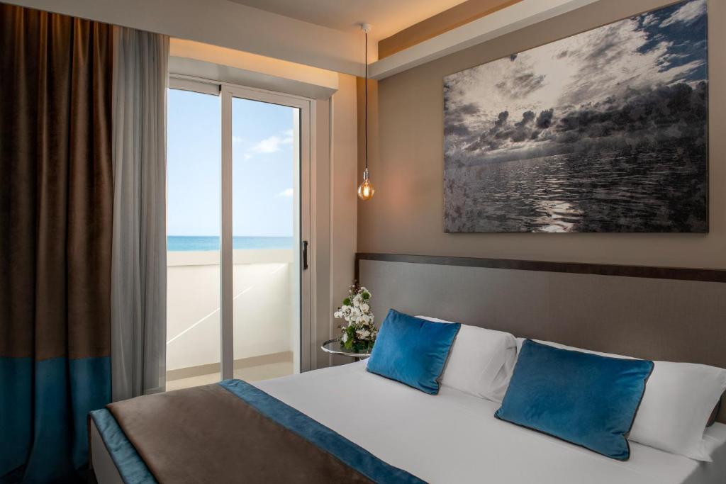 une chambre avec un lit avec vue sur l'océan dans l'établissement Hotel Continental, à Rimini