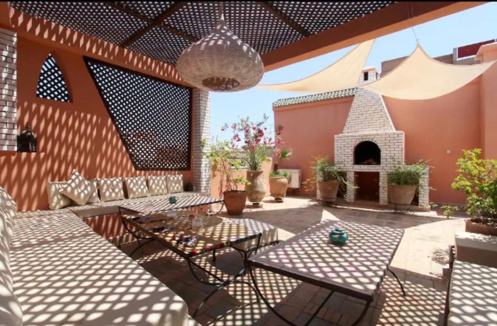 d'une terrasse avec des tables et une cheminée. dans l'établissement Riad Al Warda, à Marrakech