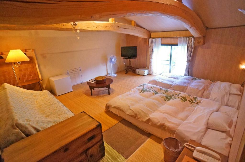 une chambre avec un grand lit dans une pièce dans l'établissement Yufunoyado Kifu, à Yufu