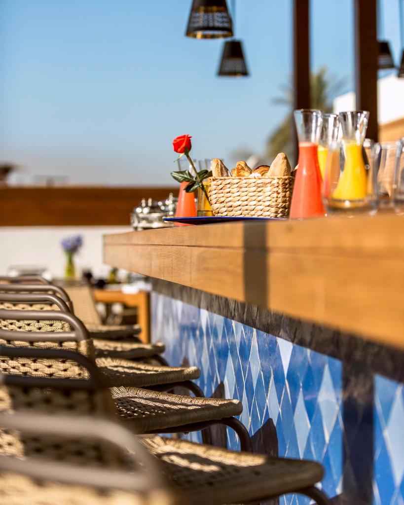 une rangée de chaises assises au comptoir d'un restaurant dans l'établissement La Brillante Marrakech, à Marrakech