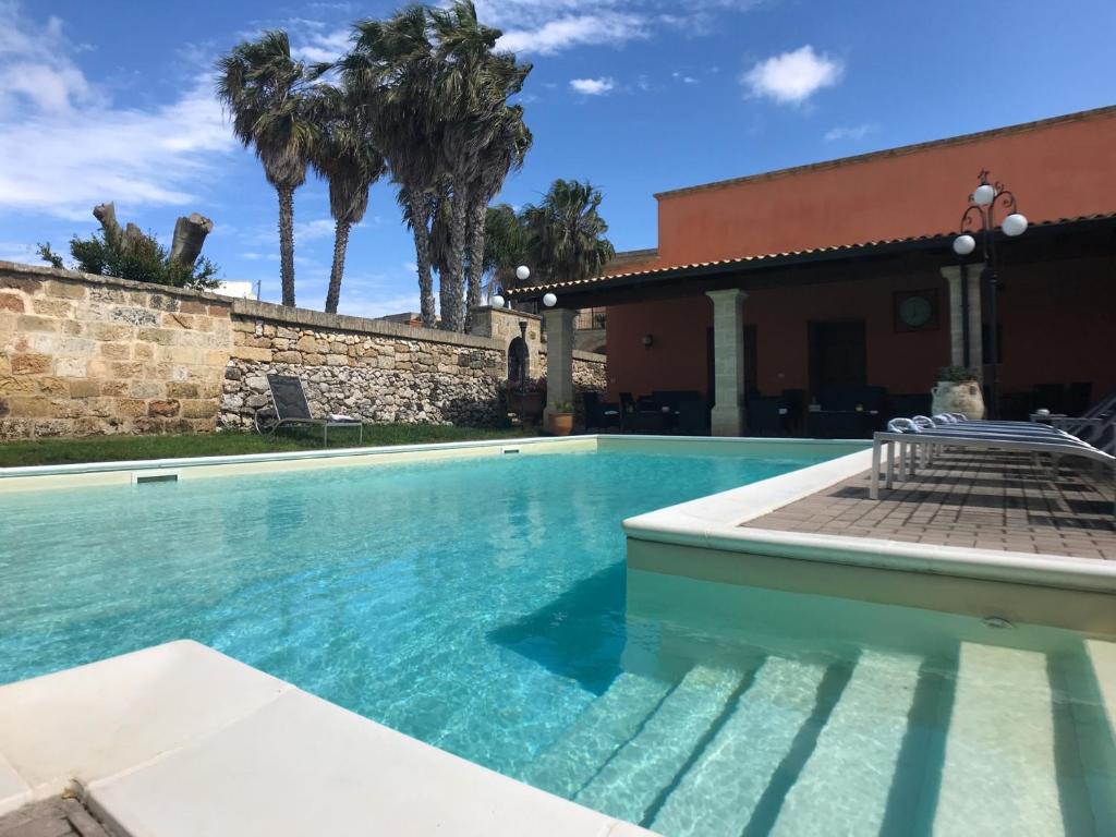 une piscine devant une maison avec des palmiers dans l'établissement VILLA EVA, à Castrignano del Capo 9 autres photos