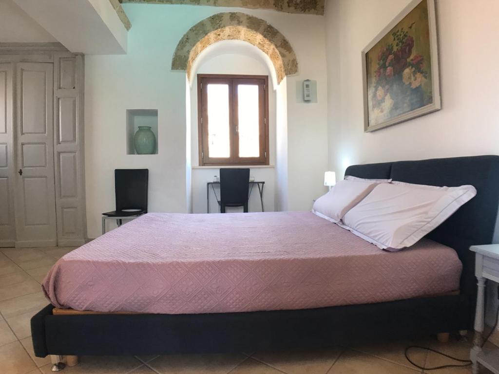 - une chambre avec un grand lit et un couvre-lit violet dans l'établissement VILLA EVA, à Castrignano del Capo
