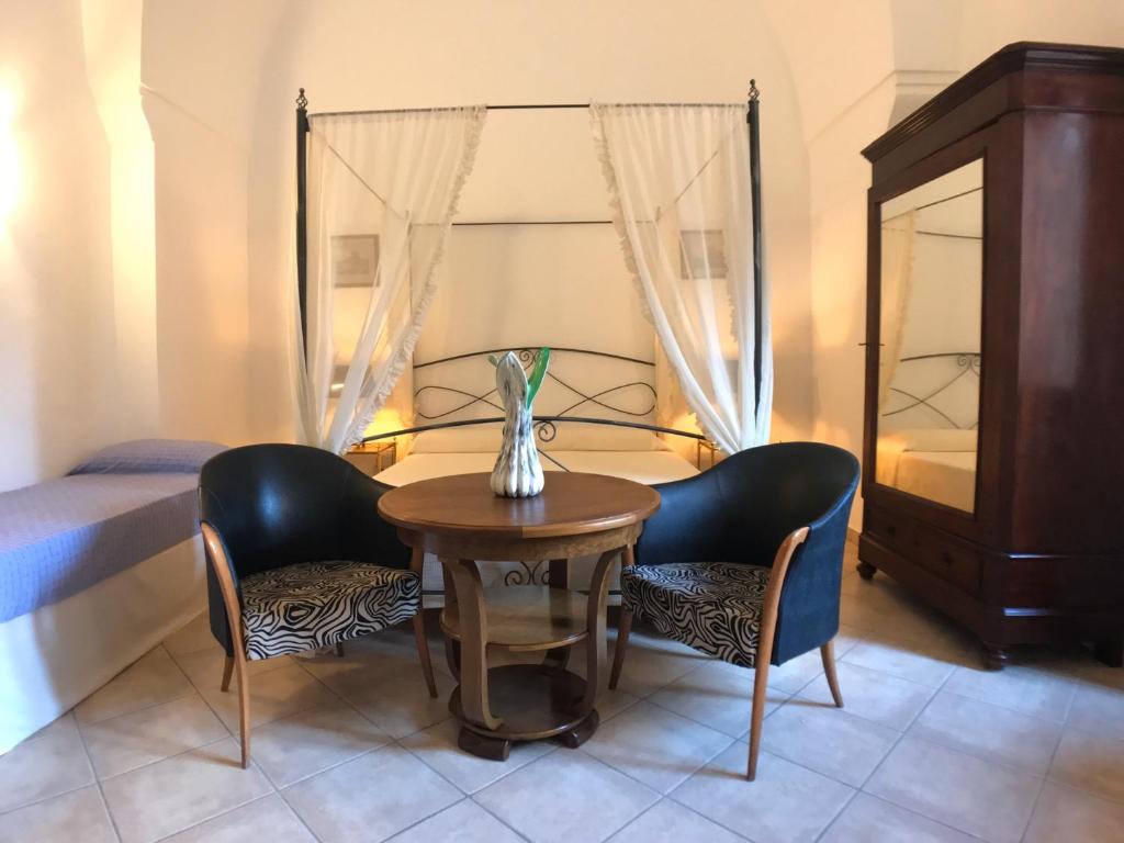 une pièce avec une table et deux chaises et un lit dans l'établissement VILLA EVA, à Castrignano del Capo