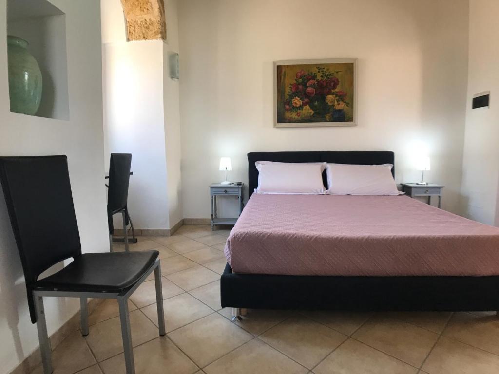 une chambre avec un lit et une chaise dans l'établissement VILLA EVA, à Castrignano del Capo