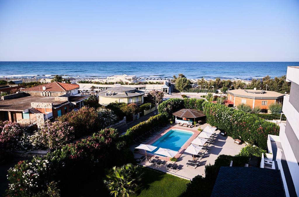 une vue aérienne d'un complexe hôtelier avec piscine et l'océan dans l'établissement Hotel Enterprise, à Montalto di Castro