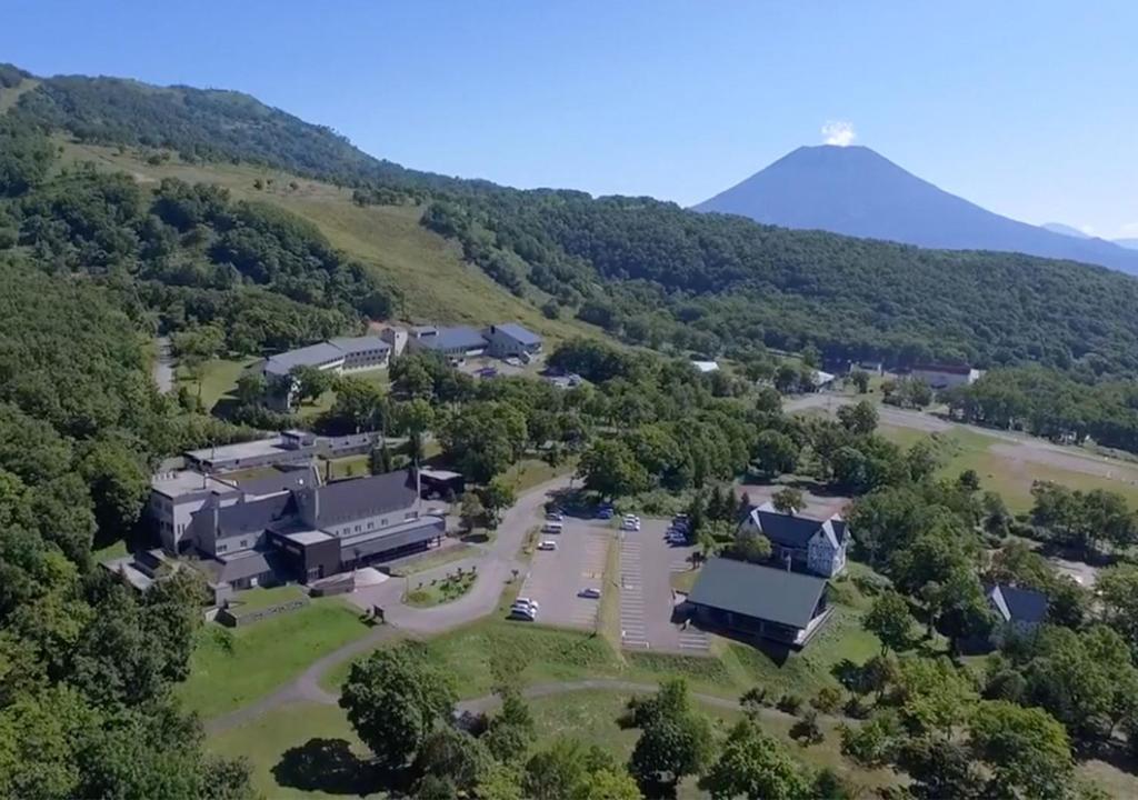 une vue aérienne d'un bâtiment avec une montagne en arrière-plan dans l'établissement Niseko Hot Spring Ikoino Yuyado Iroha, à Niseko
