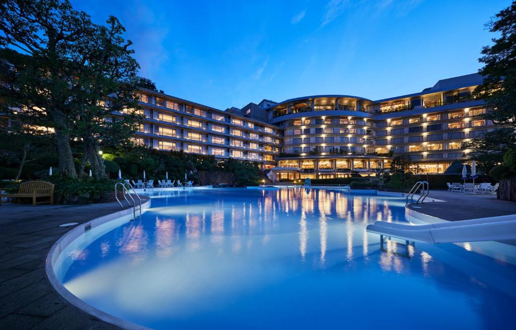 - un bâtiment d'hôtel avec une grande piscine la nuit dans l'établissement Arima Grand Hotel, à Kobe