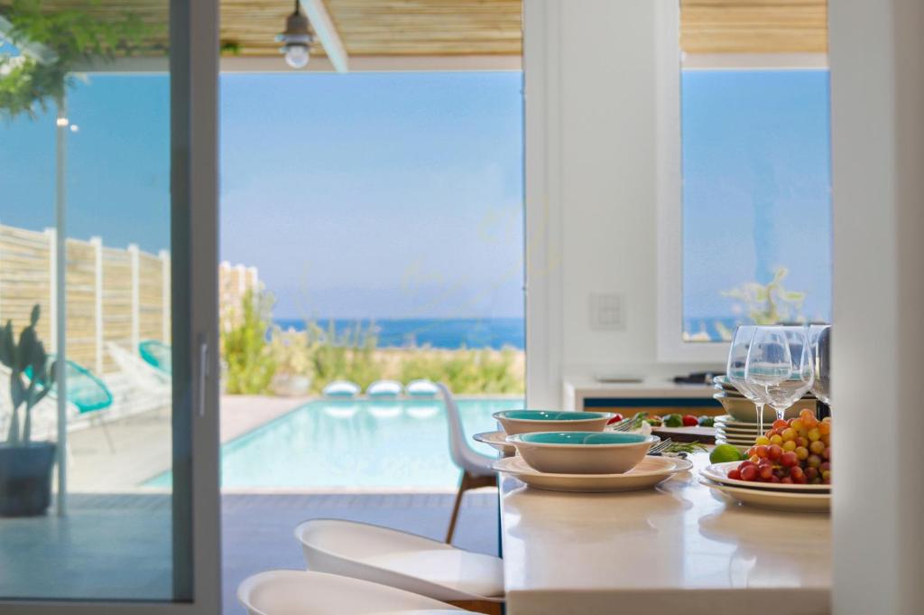 - une table à manger avec une assiette de nourriture et une piscine dans l'établissement TD Villa Levante Modern Luxury Villa with Sea View, à Monopoli